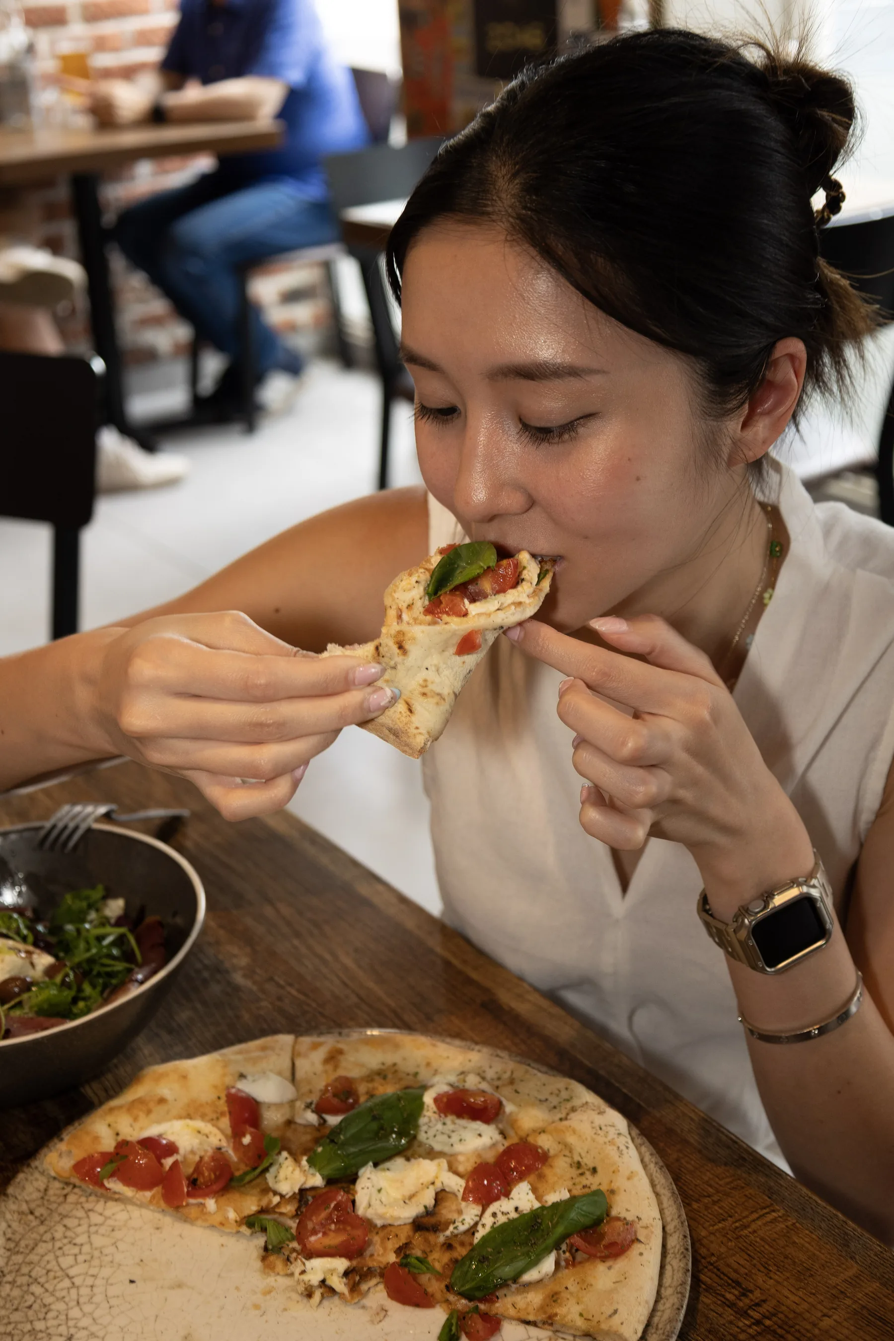 Customer biting into a slice of pizza in the dining room